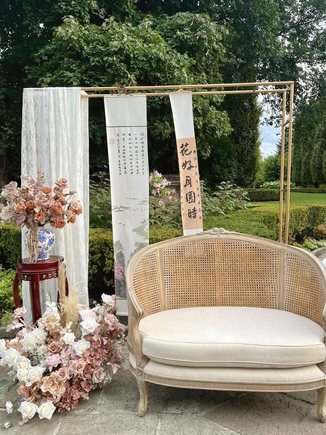 Rattan settee styled with calligraphy scrolls and dried florals