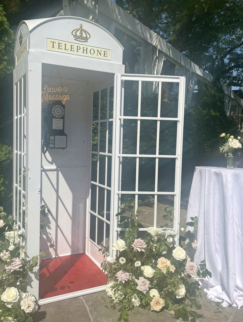 A vintage British phone booth styled as a guestbook, wrapped in florals